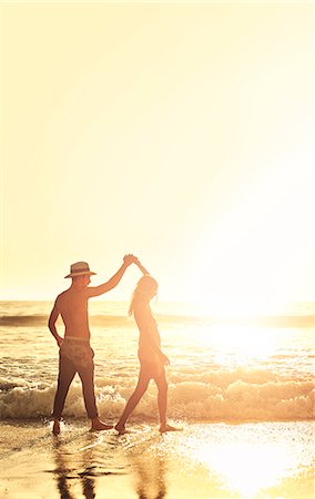 simsearch:649-03881502,k - Young couple holding hands, walking on sunny summer sunset ocean beach Foto de stock - Sin royalties Premium, Código: 6113-09027869
