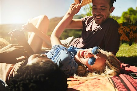 simsearch:400-07833284,k - Playful young friends laughing, relaxing on picnic blanket in sunny summer park Stock Photo - Premium Royalty-Free, Code: 6113-09027877