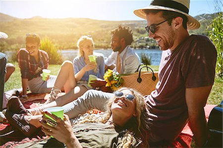 simsearch:6113-07564897,k - Young friends relaxing, enjoying picnic at sunny summer riverside Photographie de stock - Premium Libres de Droits, Code: 6113-09027875
