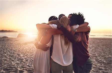 simsearch:614-08081310,k - Young friends hugging in a huddle on sunset summer beach Stock Photo - Premium Royalty-Free, Code: 6113-09027879