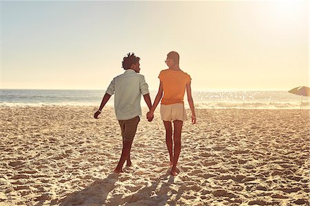 simsearch:6113-09027854,k - Young couple holding hands, walking on sunny summer beach Stock Photo - Premium Royalty-Free, Code: 6113-09027889