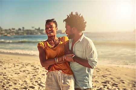 simsearch:6113-09027854,k - Playful young couple hugging and laughing on sunny summer ocean beach Stock Photo - Premium Royalty-Free, Code: 6113-09027891