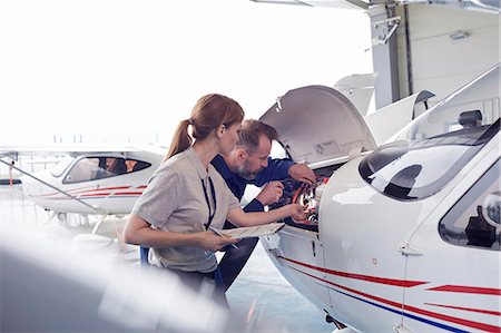 Engineer mechanics working on airplane engine in hangar Stock Photo - Premium Royalty-Free, Code: 6113-09027803