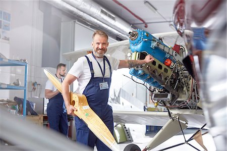 Portrait confident male engineer mechanic working on airplane in hangar Stock Photo - Premium Royalty-Free, Code: 6113-09027805