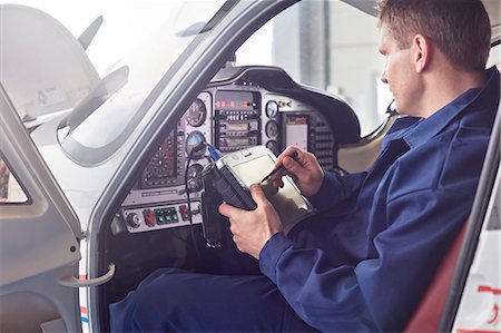 simsearch:6113-09027558,k - Male engineer checking diagnostics with digital tablet in airplane cockpit Stock Photo - Premium Royalty-Free, Code: 6113-09027815