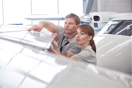 Mechanic engineers examining airplane wing in hangar Photographie de stock - Premium Libres de Droits, Code: 6113-09027820