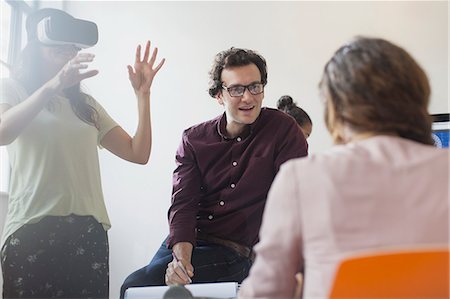 futuristic offices - Computer programmers testing virtual reality simulator glasses in conference room meeting Stock Photo - Premium Royalty-Free, Code: 6113-09144441