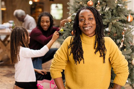 simsearch:6113-08521307,k - Portrait smiling woman decorating Christmas tree with family Fotografie stock - Premium Royalty-Free, Codice: 6113-09144564