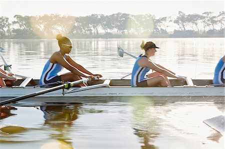 simsearch:6113-06909280,k - Female rowing team rowing scull on sunny lake Stock Photo - Premium Royalty-Free, Code: 6113-09144516