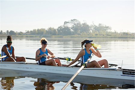 simsearch:858-05604960,k - Female rowing team resting, drinking water in scull on sunny lake Stockbilder - Premium RF Lizenzfrei, Bildnummer: 6113-09144523