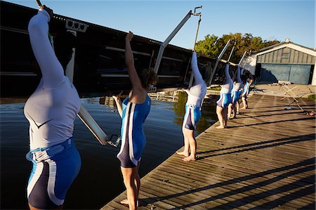 endurance - Female rowers lifting scull on sunny lakeside dock Stock Photo - Premium Royalty-Free, Code: 6113-09144535