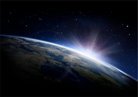 Sunlight ascending over Earth in outer space Stock Photo - Premium Royalty-Free, Code: 6113-09144755