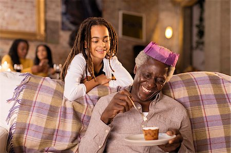 simsearch:6113-09199924,k - Granddaughter watching grandfather in Christmas paper crown eating dessert Stock Photo - Premium Royalty-Free, Code: 6113-09144701