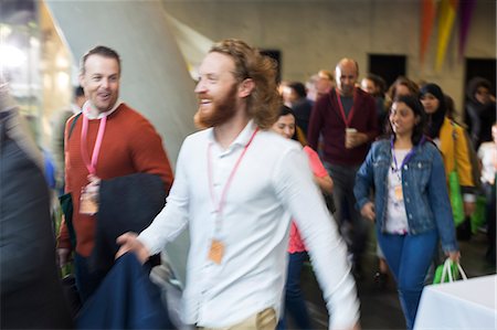 people in motion blur - Smiling people arriving at conference Stock Photo - Premium Royalty-Free, Code: 6113-09157383