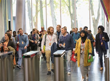 person speaking crowd - Business people arriving at conference, walking in lobby Stock Photo - Premium Royalty-Free, Code: 6113-09157393