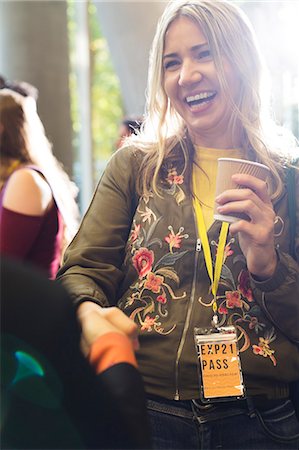 simsearch:6113-09157438,k - Smiling woman with coffee at conference Photographie de stock - Premium Libres de Droits, Code: 6113-09157396