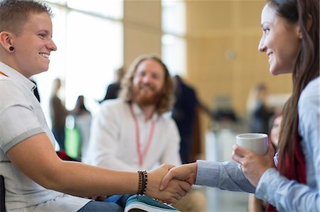 simsearch:6113-07790894,k - Businesswomen shaking hands at conference Foto de stock - Royalty Free Premium, Número: 6113-09157494