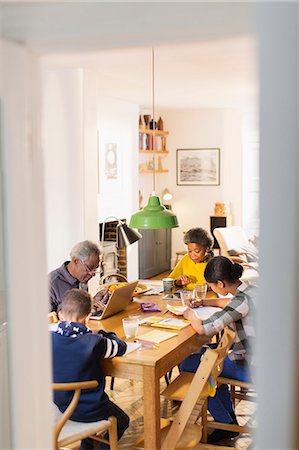 Grandparents at dining table with grandchildren doing homework Foto de stock - Sin royalties Premium, Código: 6113-09157667