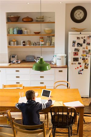 Boy doing homework at dining table Stock Photo - Premium Royalty-Free, Code: 6113-09157672