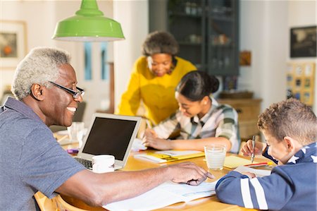 simsearch:6113-07159625,k - Grandfather helping grandson with homework at dining table Stock Photo - Premium Royalty-Free, Code: 6113-09157677