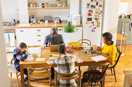 Grandparents at dining table with grandchildren doing homework Photographie de stock - Premium Libres de Droits, Code: 6113-09157632