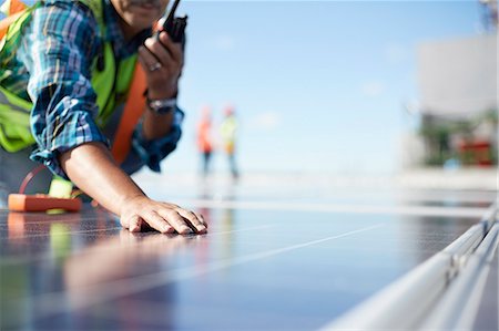 solar - Engineer with walkie-talkie inspecting solar panels at power plant Stock Photo - Premium Royalty-Free, Code: 6113-09157786