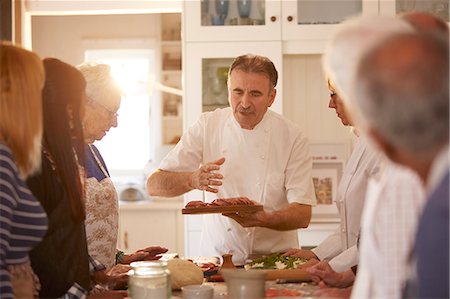 simsearch:6113-09157735,k - Senior friends listening to chef in pizza cooking class Photographie de stock - Premium Libres de Droits, Code: 6113-09157703