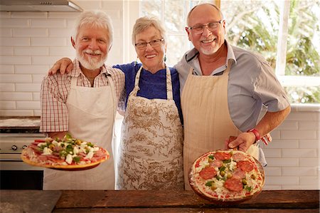 simsearch:6113-09157696,k - Portrait smiling, confident senior friends making pizza in cooking class Fotografie stock - Premium Royalty-Free, Codice: 6113-09157704