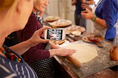 simsearch:6113-09157696,k - Woman with camera phone photographing friend making pizza dough in cooking class Fotografie stock - Premium Royalty-Free, Codice: 6113-09157710