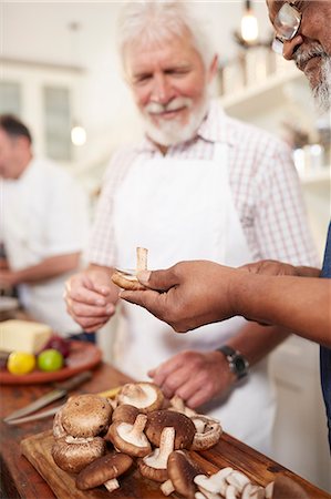 simsearch:6113-09157696,k - Senior men friends slicing fresh mushrooms in cooking class Fotografie stock - Premium Royalty-Free, Codice: 6113-09157714