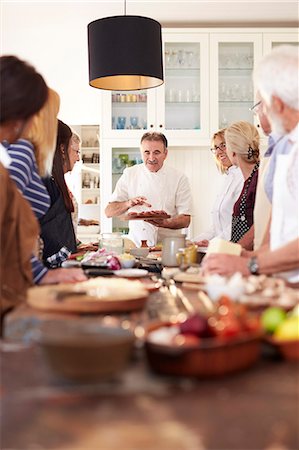 simsearch:6113-09157735,k - Senior friends listening to chef in pizza cooking class Photographie de stock - Premium Libres de Droits, Code: 6113-09157719