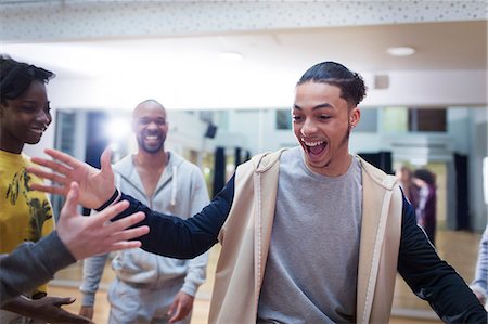 Enthusiastic teenage boy high-fiving classmate in dance class studio Stock Photo - Premium Royalty-Free, Code: 6113-09157899