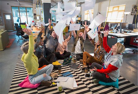 succès - Playful, enthusiastic creative business team throwing paperwork overhead in open plan office Photographie de stock - Premium Libres de Droits, Code: 6113-09159990