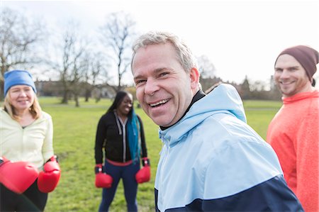 Portrait smiling, confident man boxing with friends in park Stock Photo - Premium Royalty-Free, Code: 6113-09160067