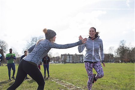 simsearch:6113-08536097,k - Women high-fiving, exercising in park Stock Photo - Premium Royalty-Free, Code: 6113-09160093