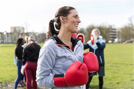 simsearch:6113-09160064,k - Smiling, confident woman boxing in park Fotografie stock - Premium Royalty-Free, Codice: 6113-09160160