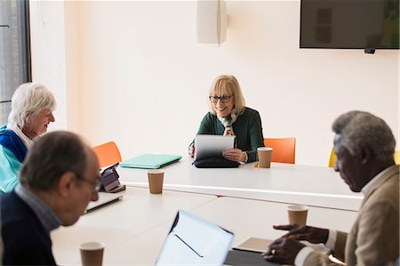 Senior businesswoman using digital tablet, leading conference room meeting Stock Photo - Premium Royalty-Free, Code: 6113-09160242