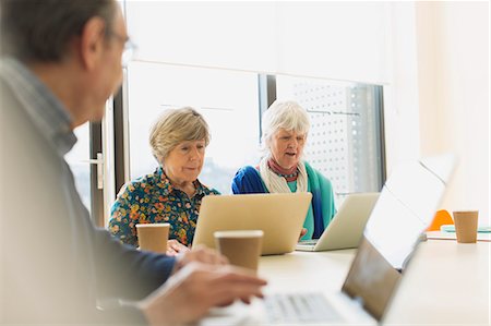 Senior businesswomen using laptops in conference room meeting Stock Photo - Premium Royalty-Free, Code: 6113-09160244