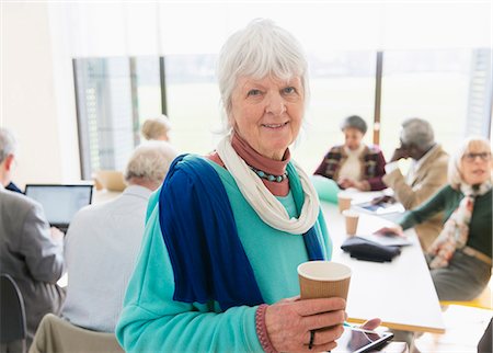 Portrait confident senior businesswoman drinking coffee in meeting Stock Photo - Premium Royalty-Free, Code: 6113-09160232