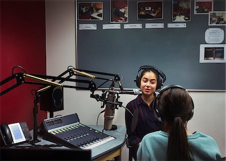 Teenage girl musicians recording music, singing in sound booth Stock Photo - Premium Royalty-Free, Code: 6113-09168261