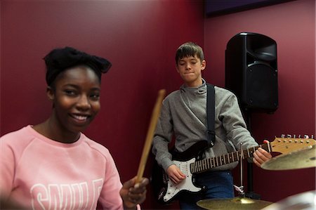 simsearch:6124-09188502,k - Smiling teenage musicians recording music, singing and playing electric guitar  in sound booth Foto de stock - Sin royalties Premium, Código: 6113-09168291