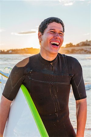 simsearch:6113-09168363,k - Laughing male surfer with surfboard on beach Photographie de stock - Premium Libres de Droits, Code: 6113-09168341