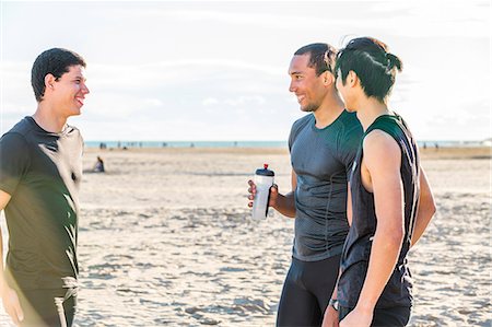 exercise black people water - Male runner friends resting, talking on sunny beach Stock Photo - Premium Royalty-Free, Code: 6113-09168347