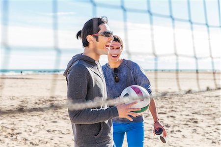 simsearch:6113-09168363,k - Happy male friends playing beach volleyball on sunny beach Photographie de stock - Premium Libres de Droits, Code: 6113-09168344