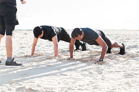 simsearch:6113-09168379,k - Men doing push-ups on sunny beach Stock Photo - Premium Royalty-Free, Code: 6113-09168348