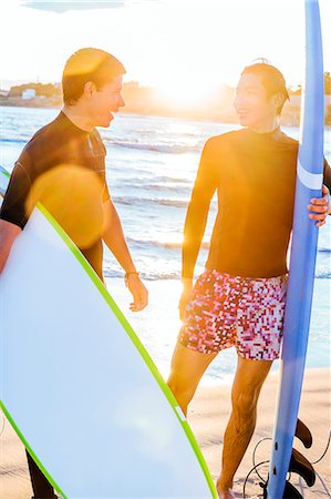 simsearch:6113-09168363,k - Male surfers with surfboards talking on sunny ocean beach Photographie de stock - Premium Libres de Droits, Code: 6113-09168377