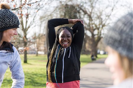 simsearch:614-08869996,k - Smiling female runner stretching in sunny park Stock Photo - Premium Royalty-Free, Code: 6113-09168309