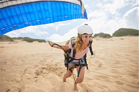 parachute, beach - Smiling female paraglider running with parachute on beach Photographie de stock - Premium Libres de Droits, Code: 6113-09168444