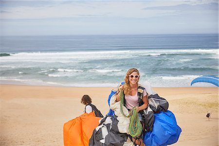 parachute, beach - Portrait smiling, confident female paraglider with equipment on sunny ocean beach Photographie de stock - Premium Libres de Droits, Code: 6113-09168477