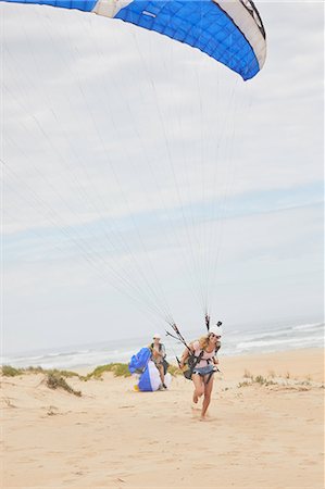 Female paraglider with parachute on ocean beach Stock Photo - Premium Royalty-Free, Code: 6113-09168478